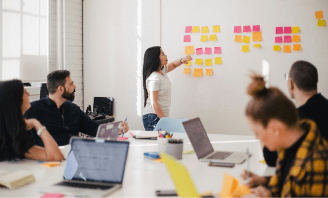 atelier créatif avec plusieurs personnes et avec des post-it au mur