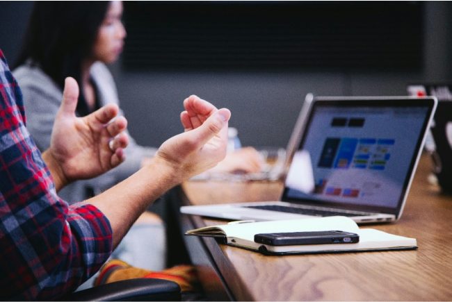 personne sur son ordinateur faisant des gestes de la main